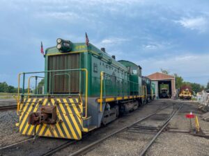 a green train that is sitting on a railroad track